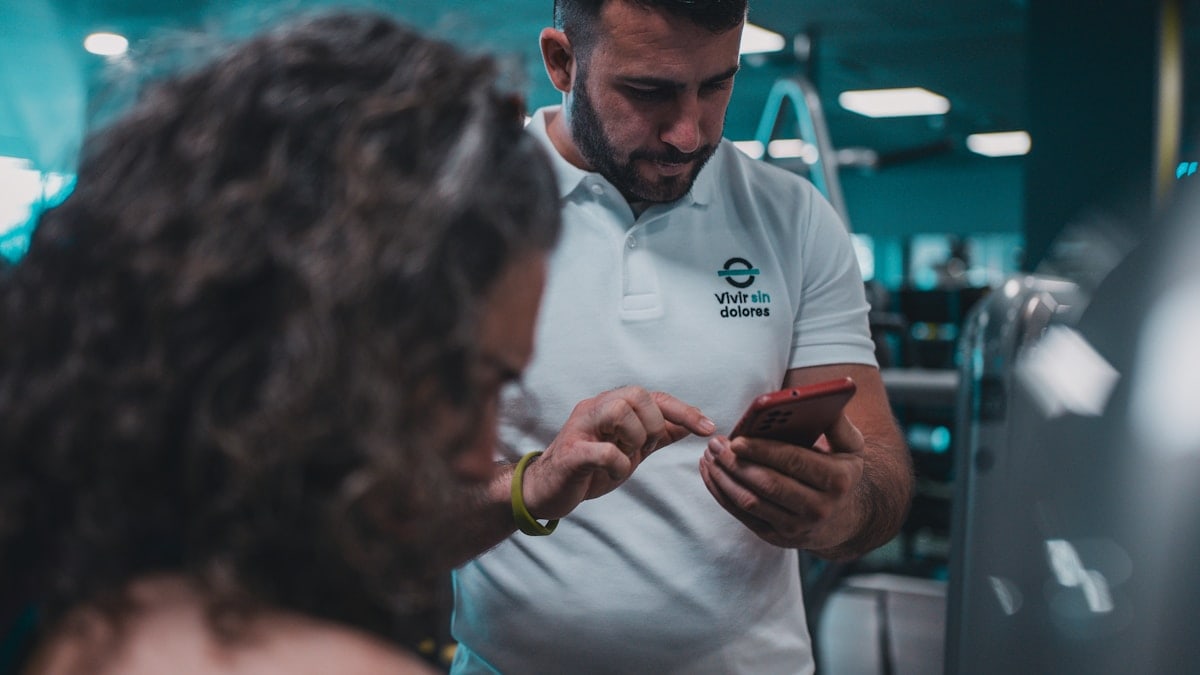 Sesión de entrenamiento en el gimnasio con un entrenador personal, enfocada en el rendimiento y el bienestar físico.